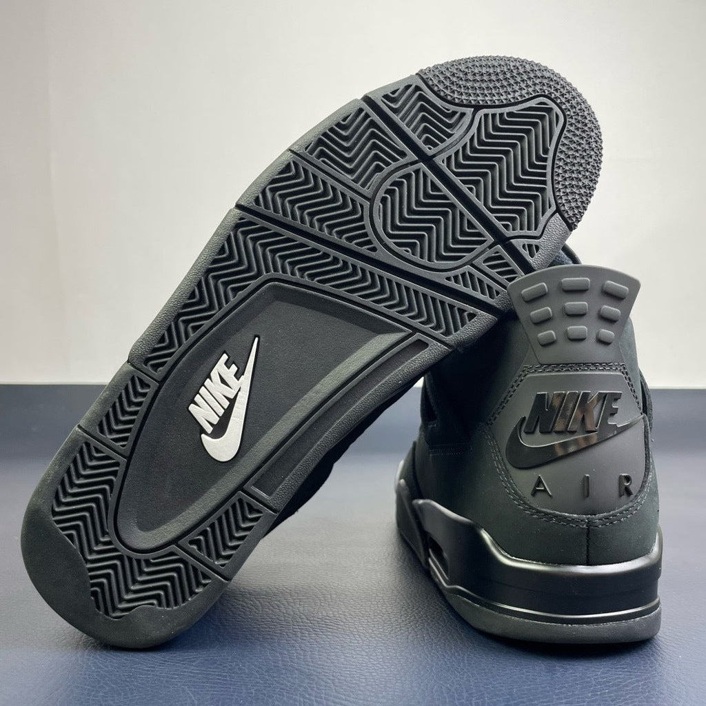 Air Jordan 4 Black Cat - outsole view showing black rubber with white Nike Swoosh