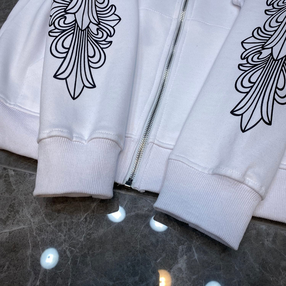 Chrome Hearts white zip-up hoodie full front view showing black floral cross sleeve graphics and horseshoe chest logo