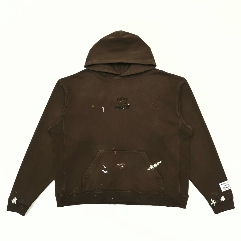 Gallery Dept. hoodie cuff detail with white paint brushstrokes and art label