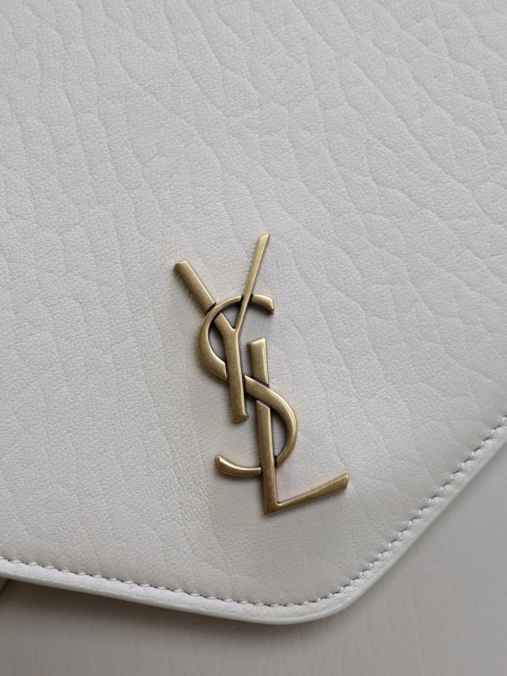 Saint Laurent Cassandra envelope bag gold YSL cassandre monogram hardware close-up on cream leather