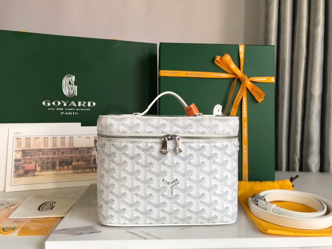Goyard Vanity Case white Goyardine canvas front view with silver hardware and orange handle accent