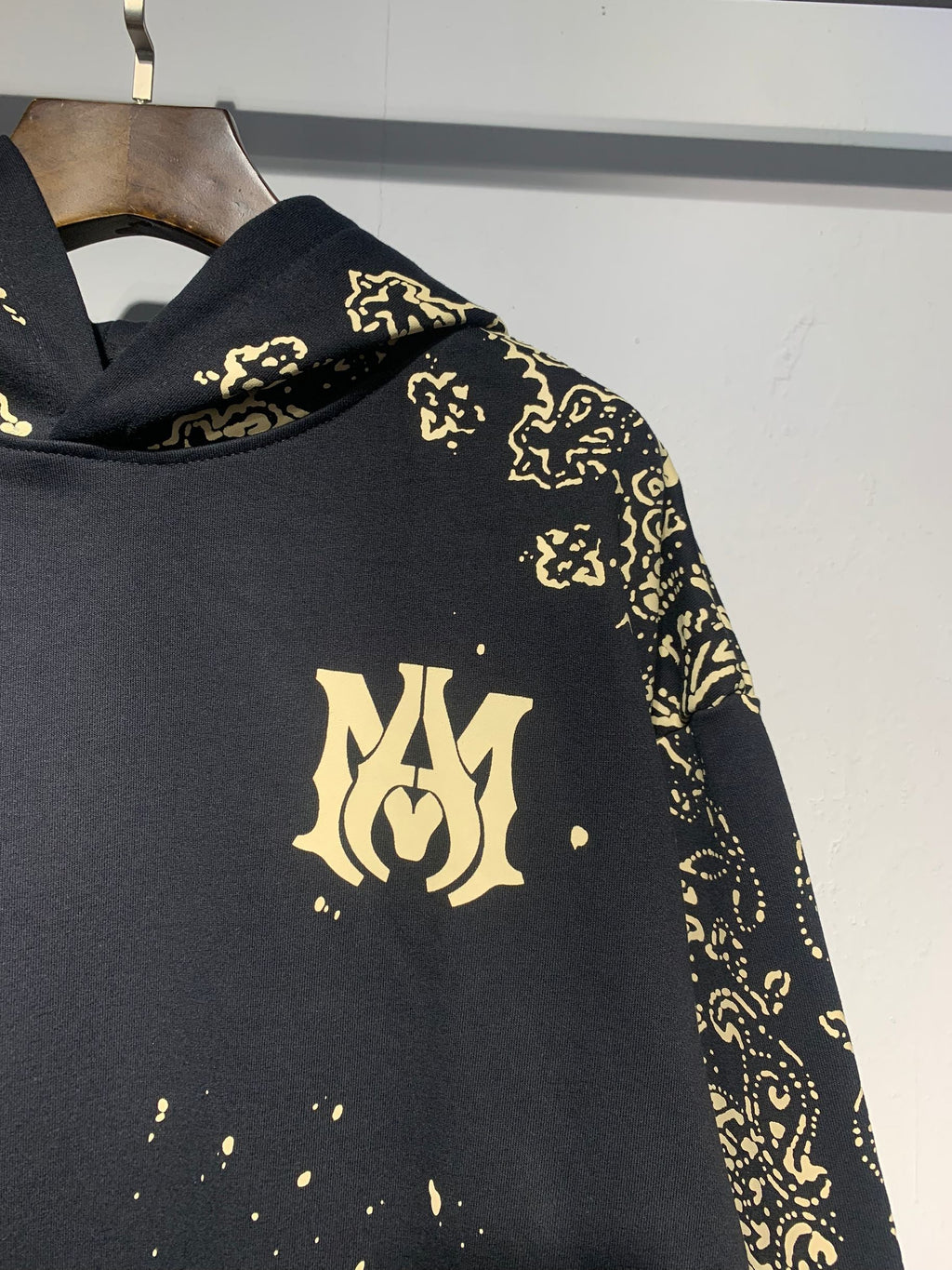 Amiri Paisley Bandana Hoodie – Black Gold MA monogram chest close-up with paisley sleeve detail