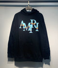Amiri Staggered Iridescent Logo Hoodie – Black front view on hanger
