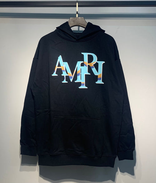 Amiri Staggered Iridescent Logo Hoodie – Black front view on hanger