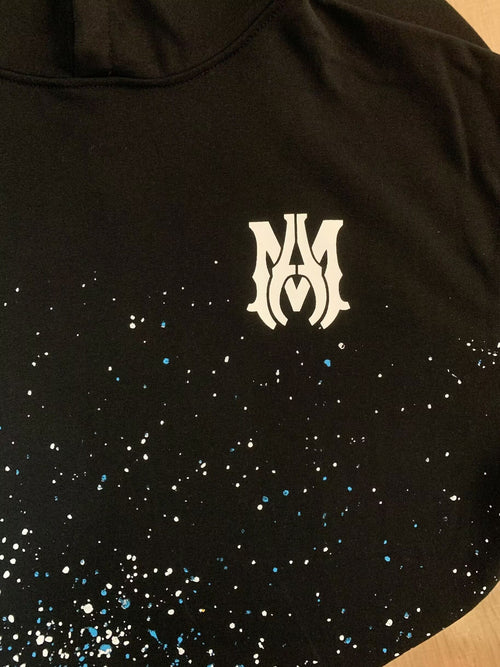 Amiri Paint Splatter Hoodie – Black front view with MA monogram