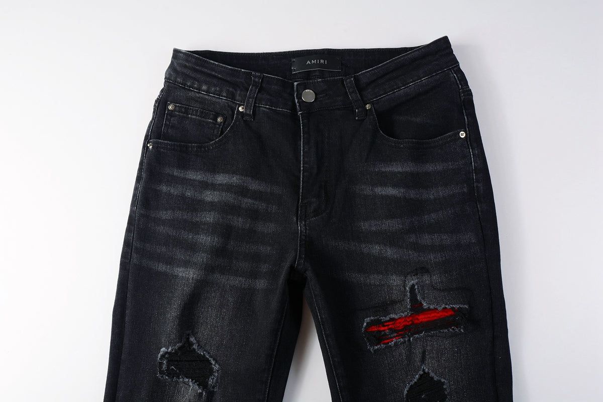 Close-up of red ribbed patch detail through distressed knee rip
