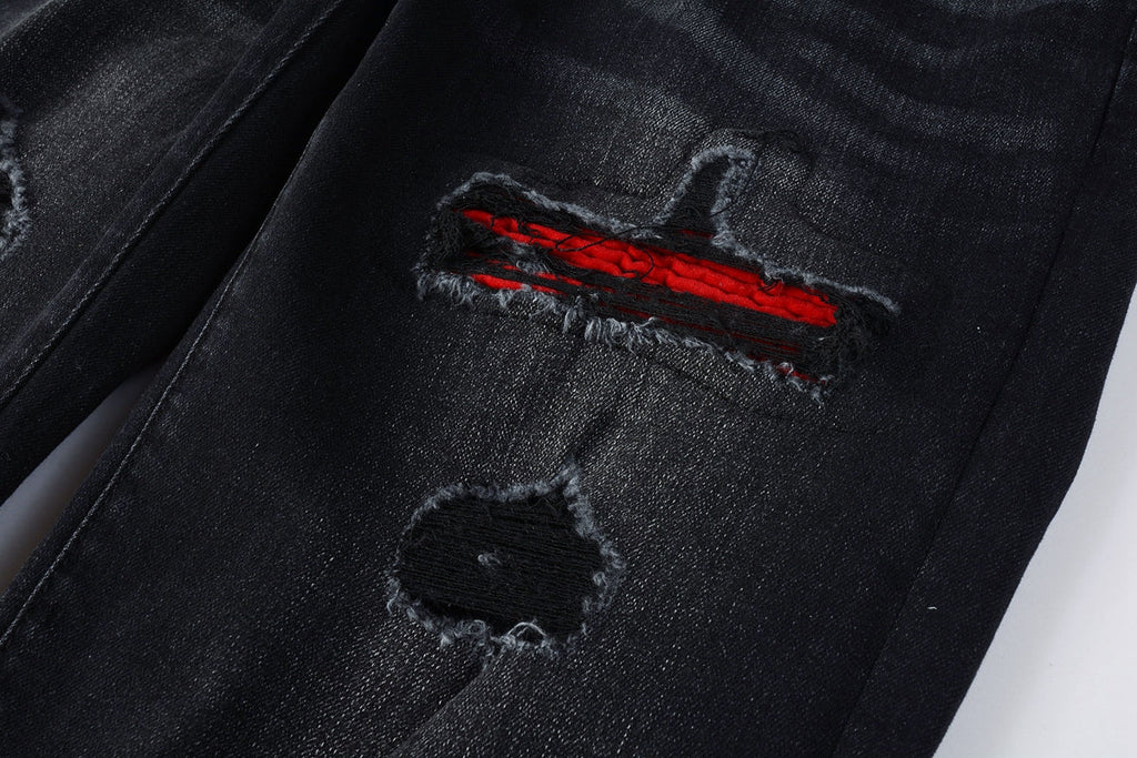 Close-up of distressed rip with red patch detail on leg