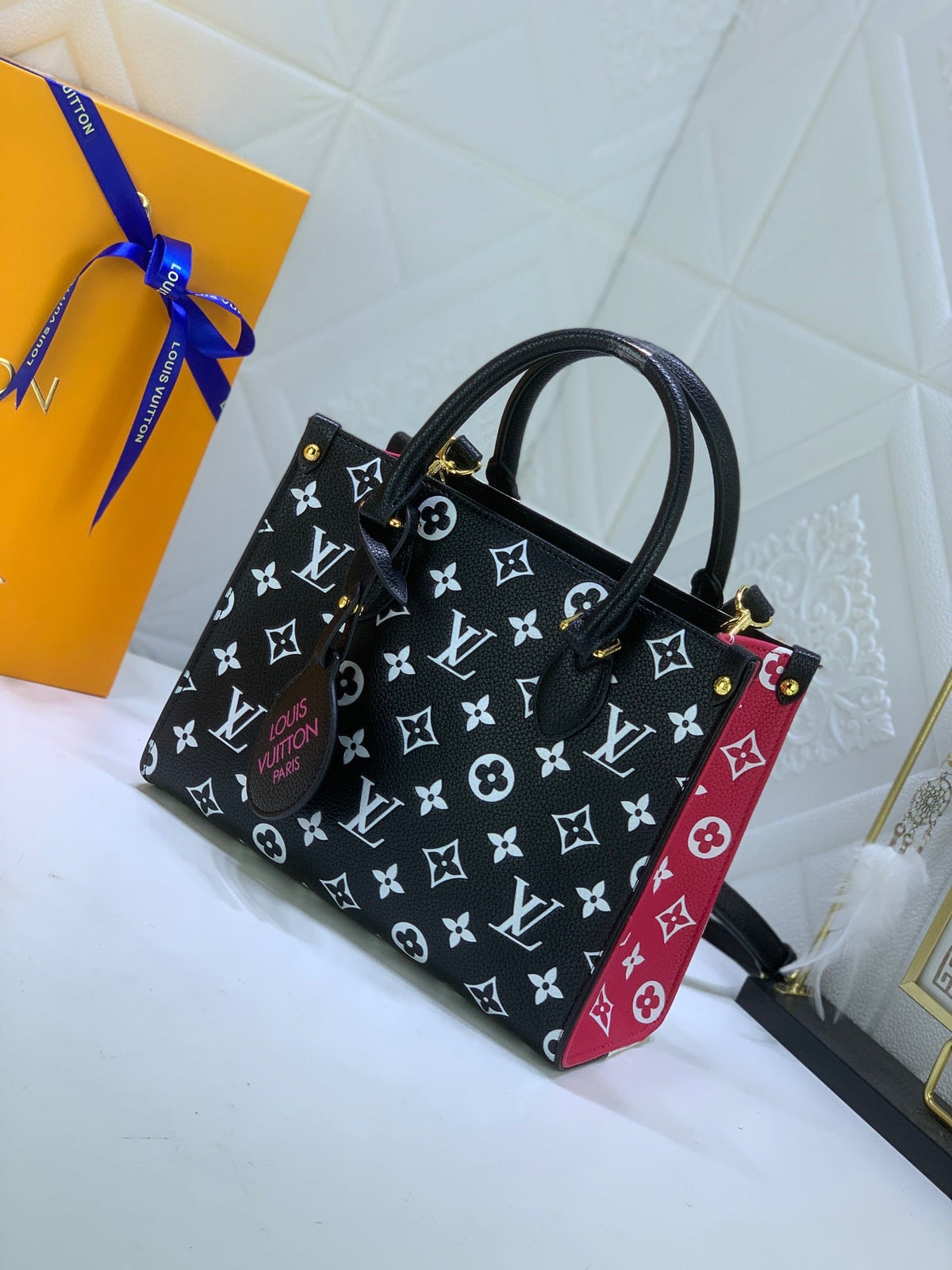 LV OnTheGo MM Bicolor – side view red monogram panel